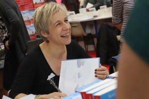 Agnès Ledig. Sur le stand Albin Michel, l'auteur dédicace Dans le murmure des feuilles qui dansent.